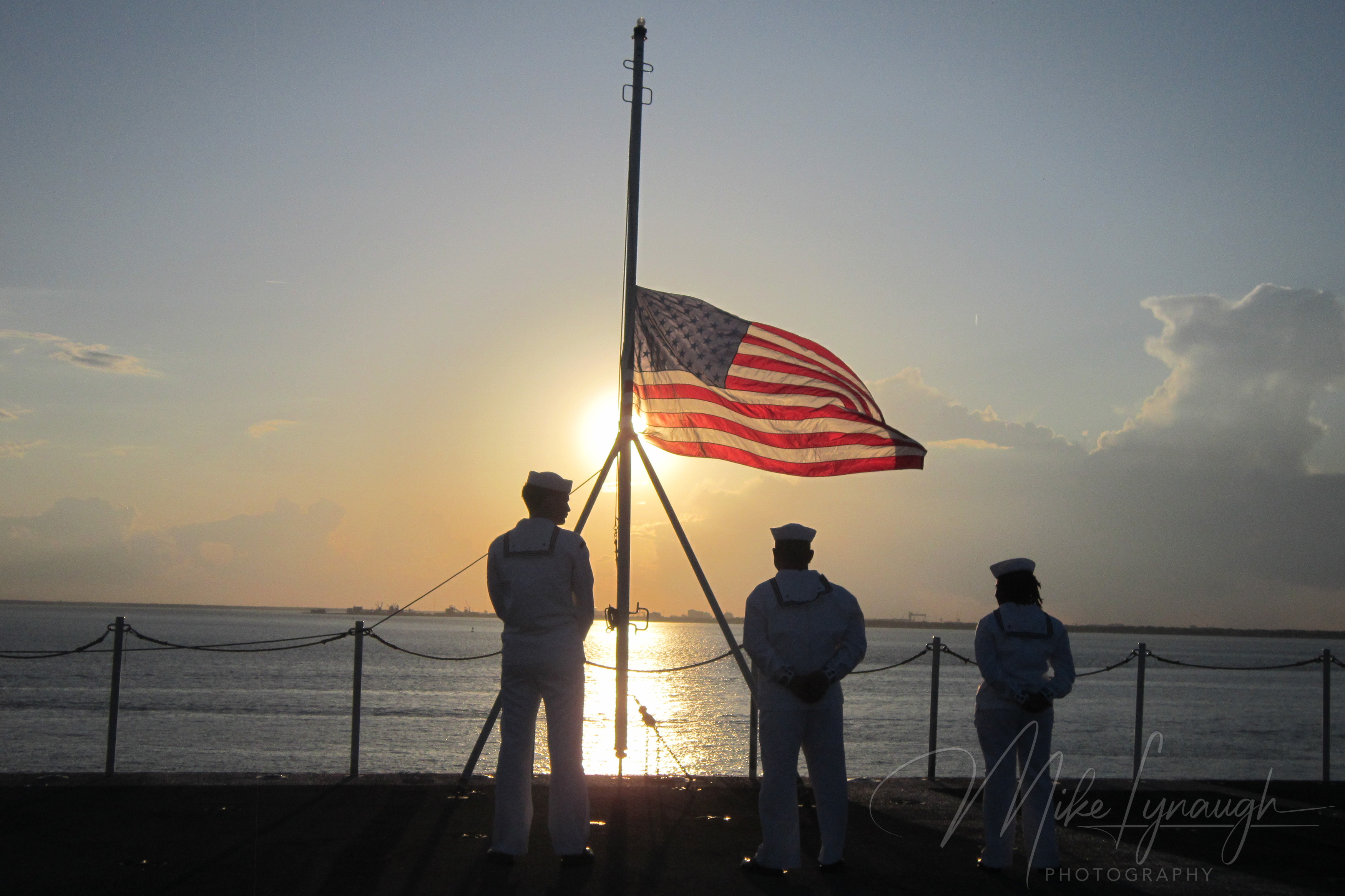 Sailors and American flag at sunset
