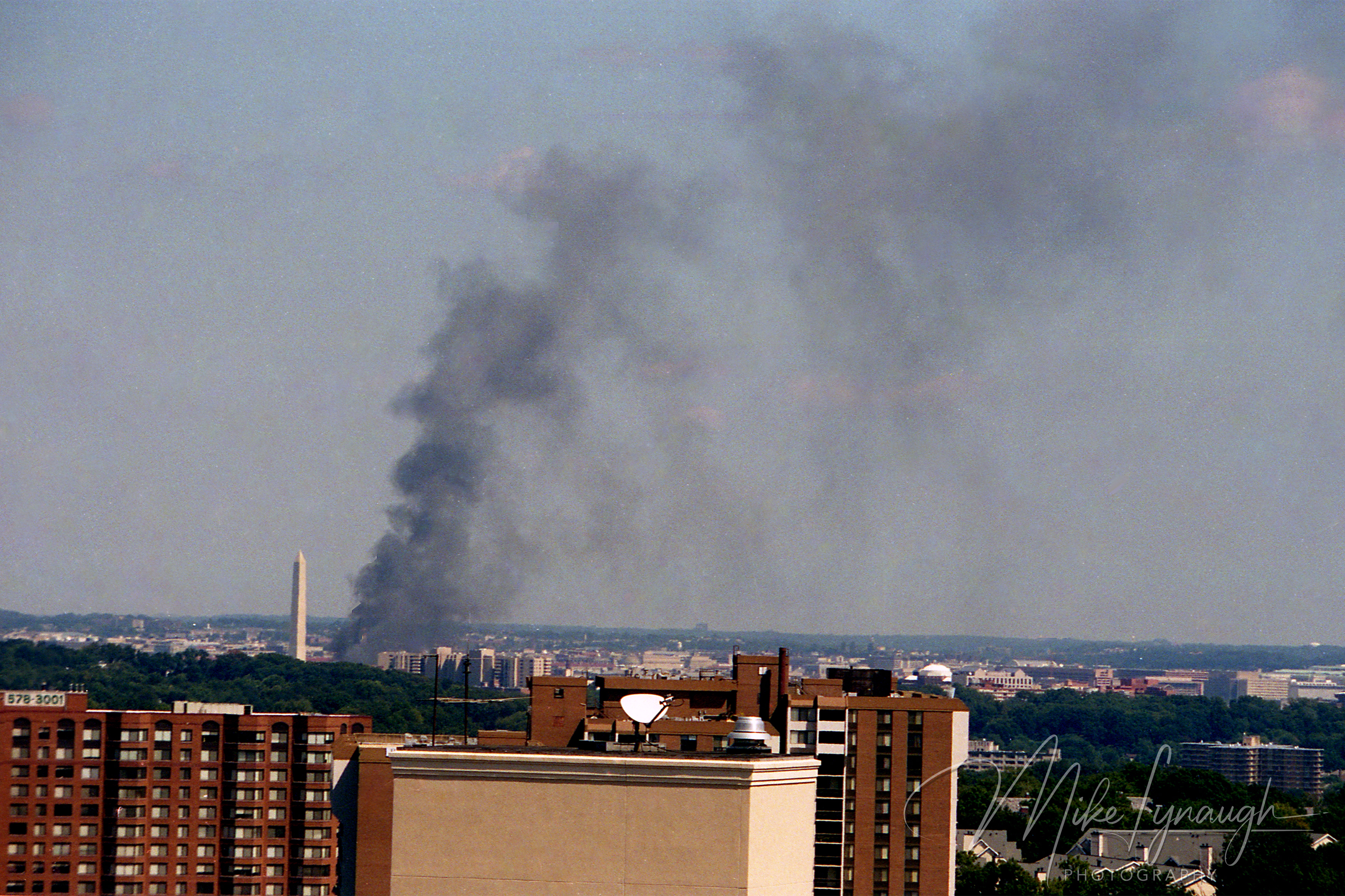 Distant rooftop view of dark smoke rising from the Pentagon near the Washington Monument on September 11 2001