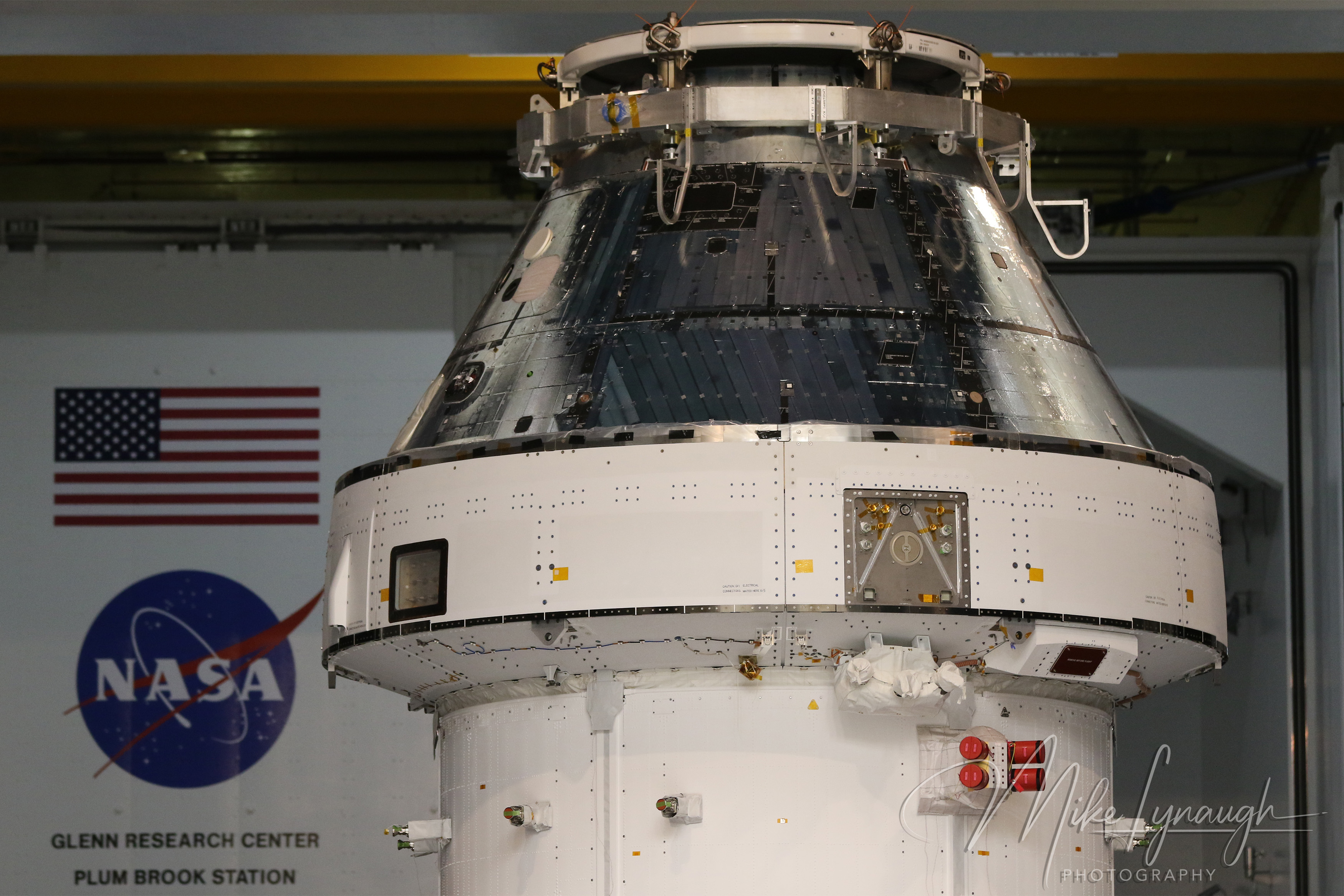 A detailed close-up photograph of the Artemis I Orion spacecraft and service module showing hardware and thermal protection systems.