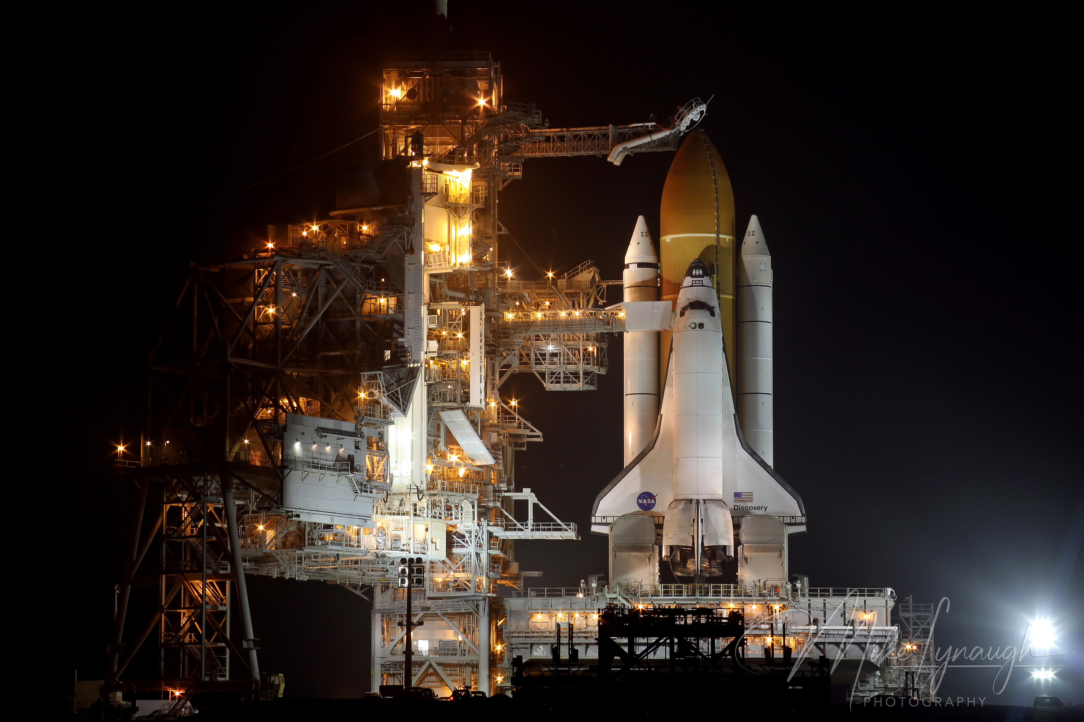 NASA’s Space Shuttle Discovery (OV-103) sits illuminated on Launch Pad 39A at Kennedy Space Center, Florida, on the eve of its final mission, STS-133, to the International Space Station.