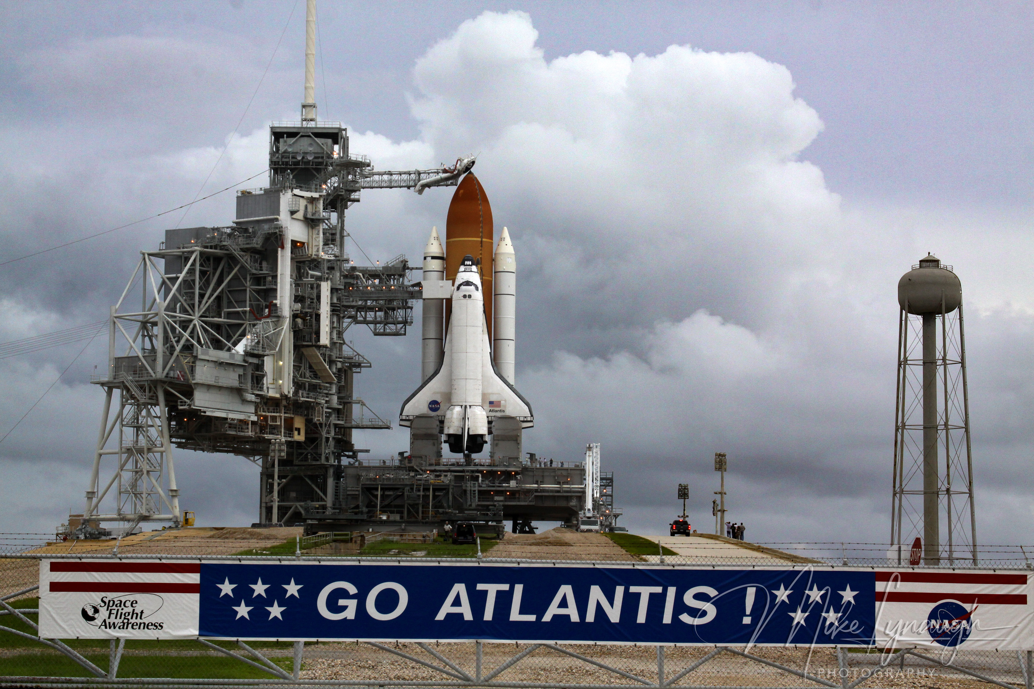A wide horizontal view of Launch Pad 39A at NASA’s Kennedy Space Center on July 7, 2011, featured behind a perimeter fence decorated with a "Space Flight Awareness - GO ATLANTIS!" banner.